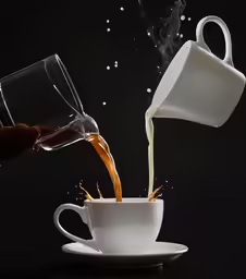the coffee is being poured into a mug