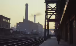 there is a person walking on the train platform near buildings