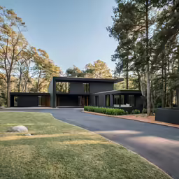 modern home with large driveway and lush green yard