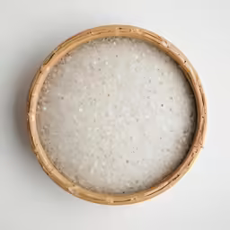 a basket filled with rice is placed next to a wall