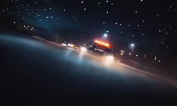 a truck driving down the street at night with street lamps on