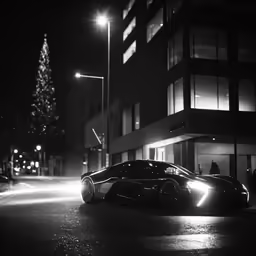 an electric vehicle parked on the street next to a building at night