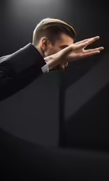 a man in suit holding his hand out to catch something