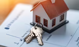 a home key sits on top of a tax statement
