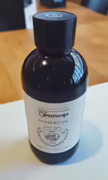 a bottle sitting on top of a wooden table