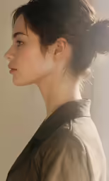 a woman with her hair in a bun wearing a dress