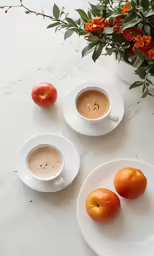 two white plates topped with oranges and a cup of coffee