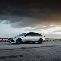 white luxury car parked on the side of a highway