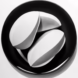four pieces of pills are shown in a black and white plate