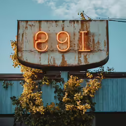 a rusted out sign outside of a building with the letters 1933