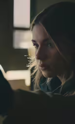 a girl holding a cell phone and looking to the side