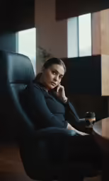 a young woman sitting in a leather chair