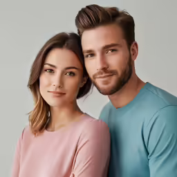 the couple, posing in front of the camera, has an eye looking to their right