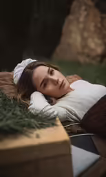 a girl posing with her arms folded up while laying on the ground