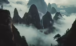 a black and white photo shows a mountain range in a cloudy scene