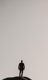 the lone person stands on top of a large hill