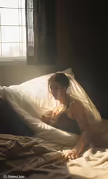 a woman is in a bed with her bare chest