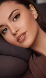 a woman with dark eye makeup and gold eyeshadow posing