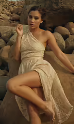 the woman is wearing a sexy gown near some rocks