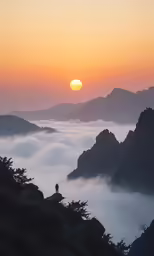 sunset above some hills and fog covered mountains