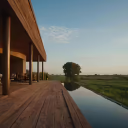 wooden deck outside with grass and a house in the background