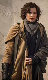 a woman holding a gun next to a building