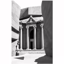 architecture in black and white shows two pillars and a circular doorway, with light reflecting off of it