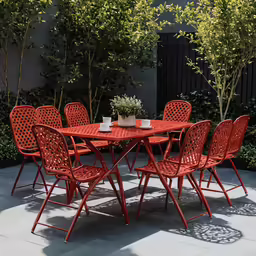 an orange table and chairs set up in the shade