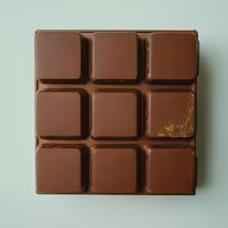 the piece of chocolate is half covered in gold
