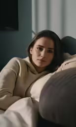a woman laying on a bed with her arms crossed