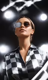 a woman wearing sunglasses with lights in the background