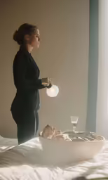 a woman in a dark top and skirt on the bed