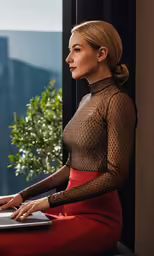 woman in tight, red pants and sheer top working on her laptop computer