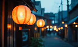 three glowing chinese paper lanterns hanging above a walkway