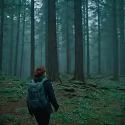 a red headed woman walking in the forest