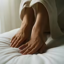 the woman is touching the bed and making a face