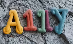 a pair of letters spelling out alika in colorful, felt word shapes