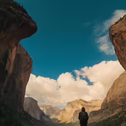 a man standing on a road with a view of the mountain and valley