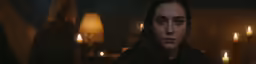 a close up of a person in a room with lit candles