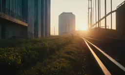 the sun sets behind train tracks in an industrial setting
