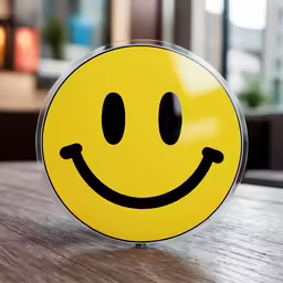 a yellow smiley face on the table with a blurry background