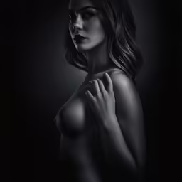 a nude woman standing on a black background