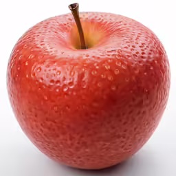 a shiny red apple with a yellow center and some water drops