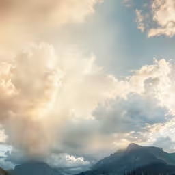 several cows graze on green pasture with large mountains in the background,cloudy clouds, mountains and blue sky at sunrise