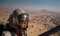 a girl wearing a helmet and holding a jet in her hands