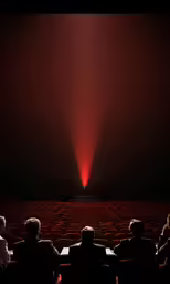 people sitting in a movie theater watching a light show