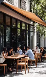 a group of people sitting around a restaurant table in the sun