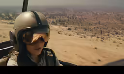 a man in a plane cockpit wearing a helmet and goggles