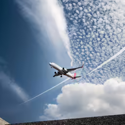 a plane flies over a city and a wall
