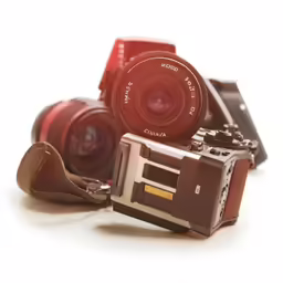 two different vintage cameras are being held in a single image